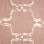 Detail of fabric in a leafy lattice print in cream on a pink field.