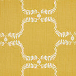 Detail of fabric in a leafy lattice print in white on a mustard field.