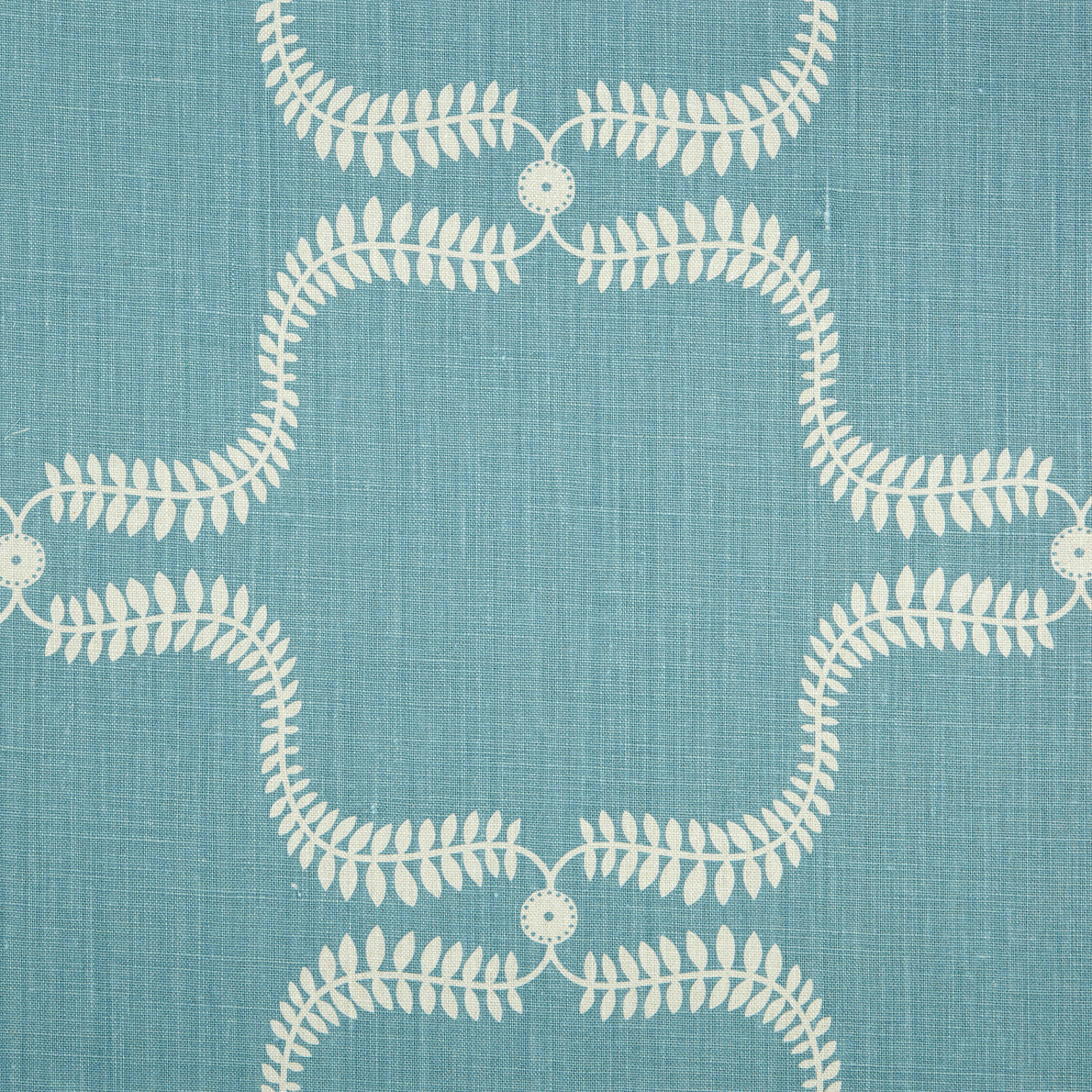 Detail of fabric in a leafy lattice print in cream on a blue field.