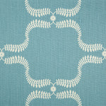 Detail of fabric in a leafy lattice print in cream on a blue field.