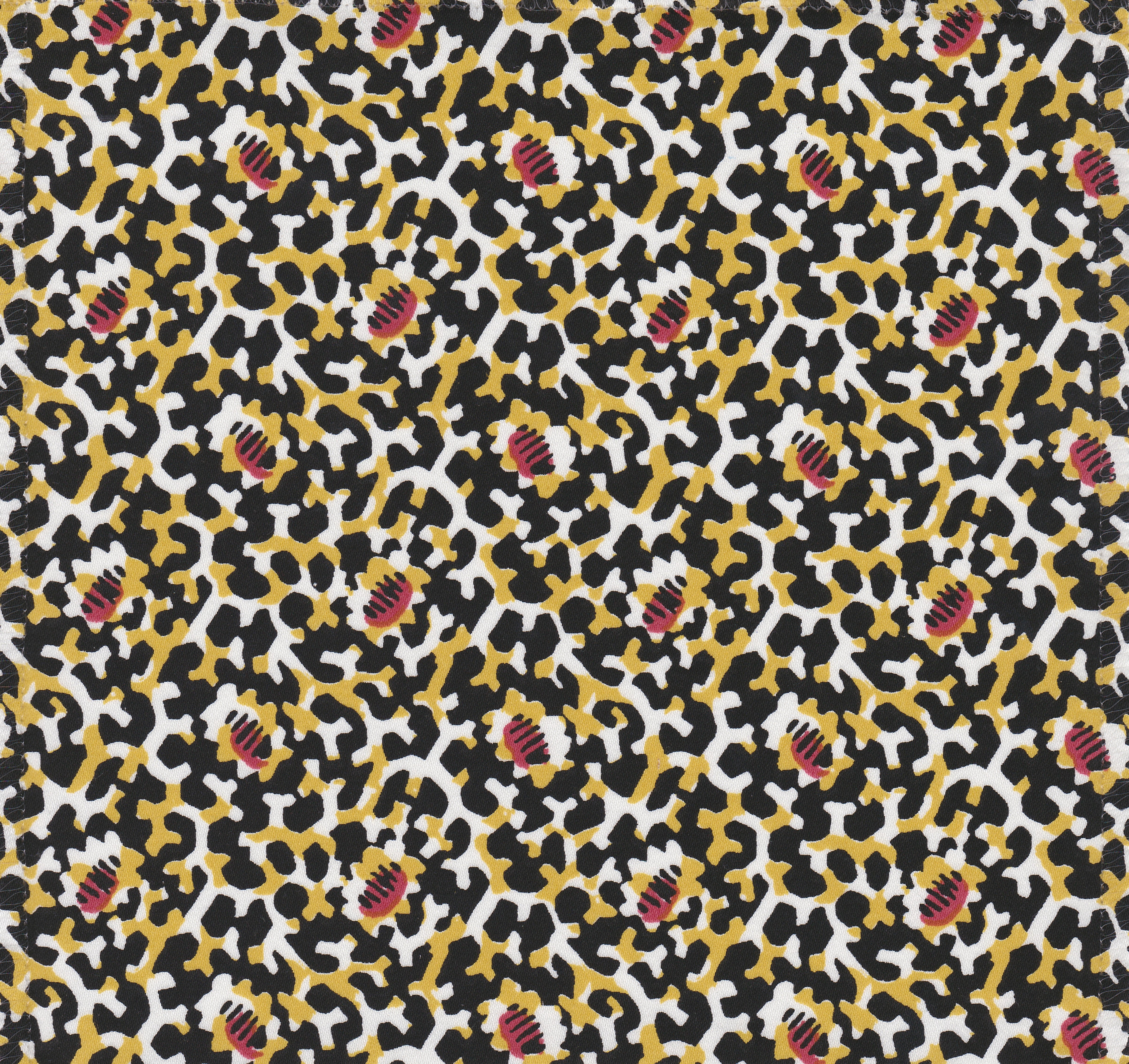 Detail of fabric in a playful irregular botanical print in red, yellow and black on a white field.