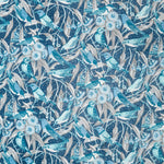 Fabric detail of a dense bird and branch pattern in shades of blue, turquoise and grey.