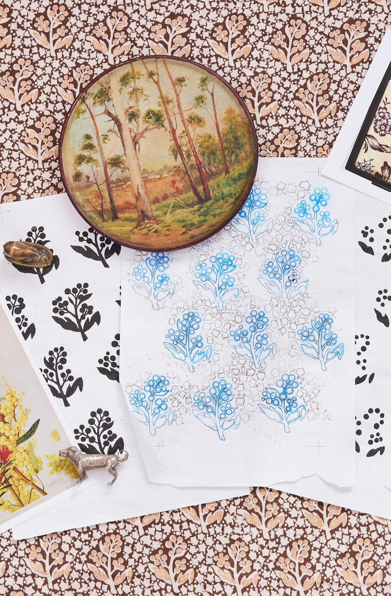 Collection of floral and nature-themed sketches on a floral patterned fabric