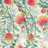 Draped fabric in a dense floral print in shades of yellow, pink and green on a white field.