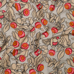 Draped fabric in a leaf and bud print in shades of tan, pink and yellow on a light gray field.