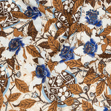 Draped fabric in a dense hibiscus print in white, navy and brown on a cream field.