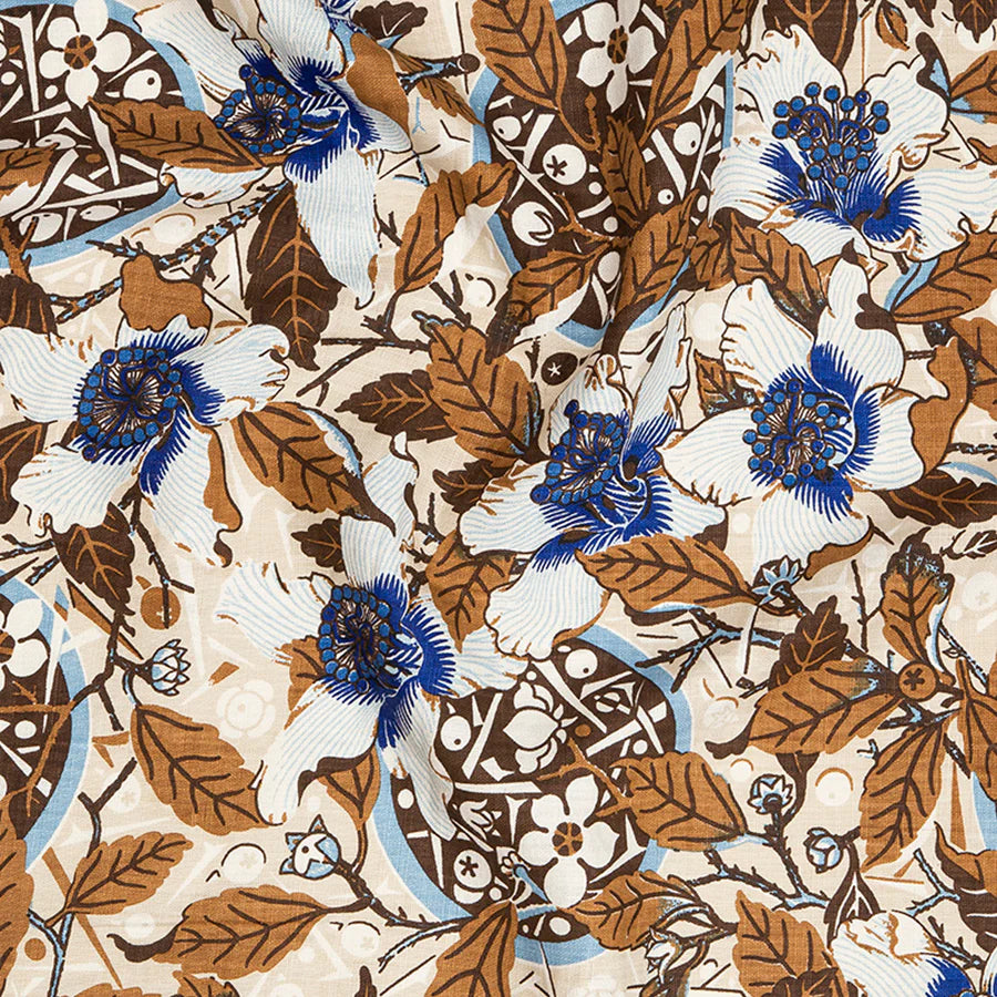 Draped fabric in a dense hibiscus print in white, navy and brown on a cream field.