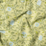 Draped fabric in a floral print in shades of blue and green on a yellow field.