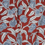 Draped fabric in a painterly floral print in blue, white and on a red field.