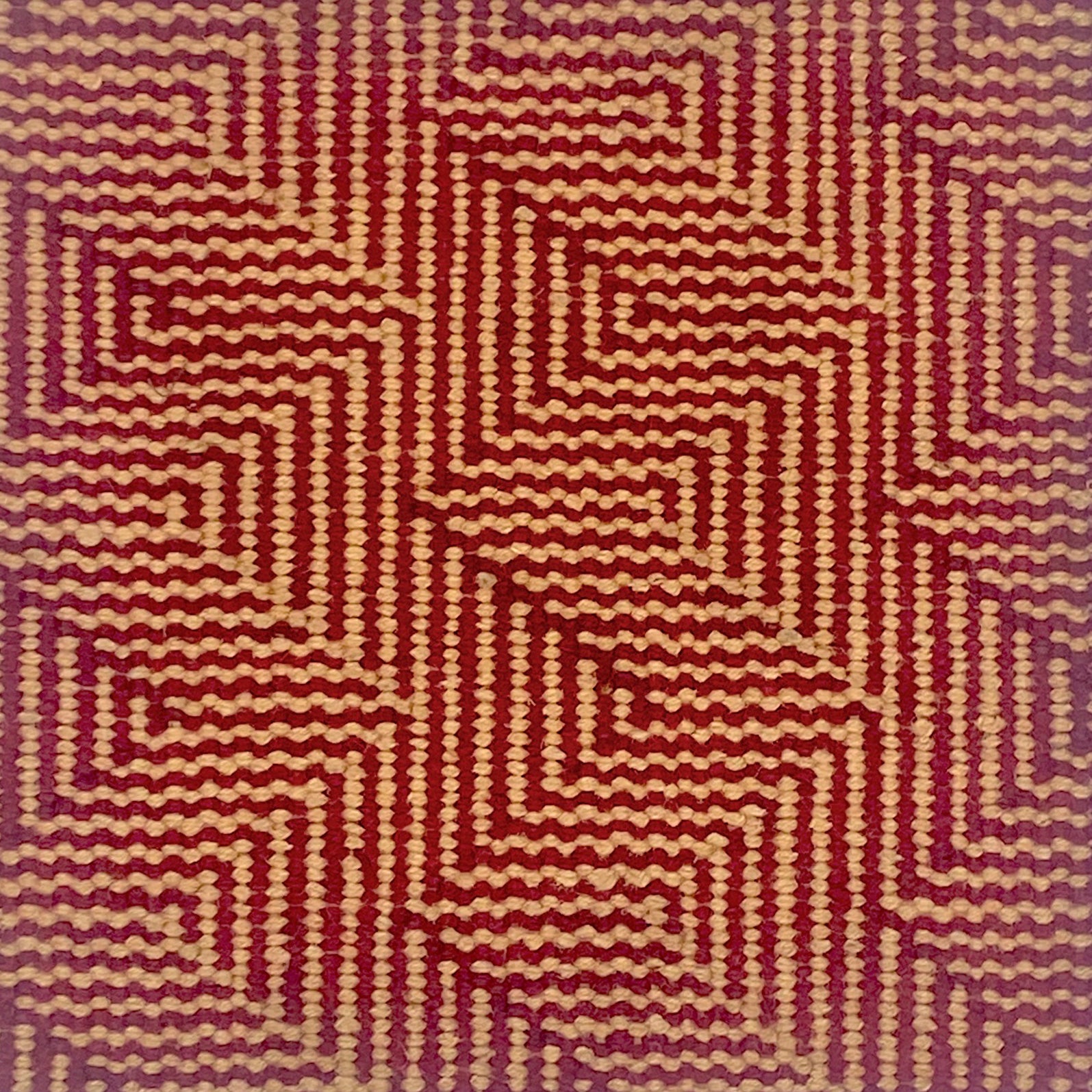 Patterned carpet with a zigzag design in red and beige.