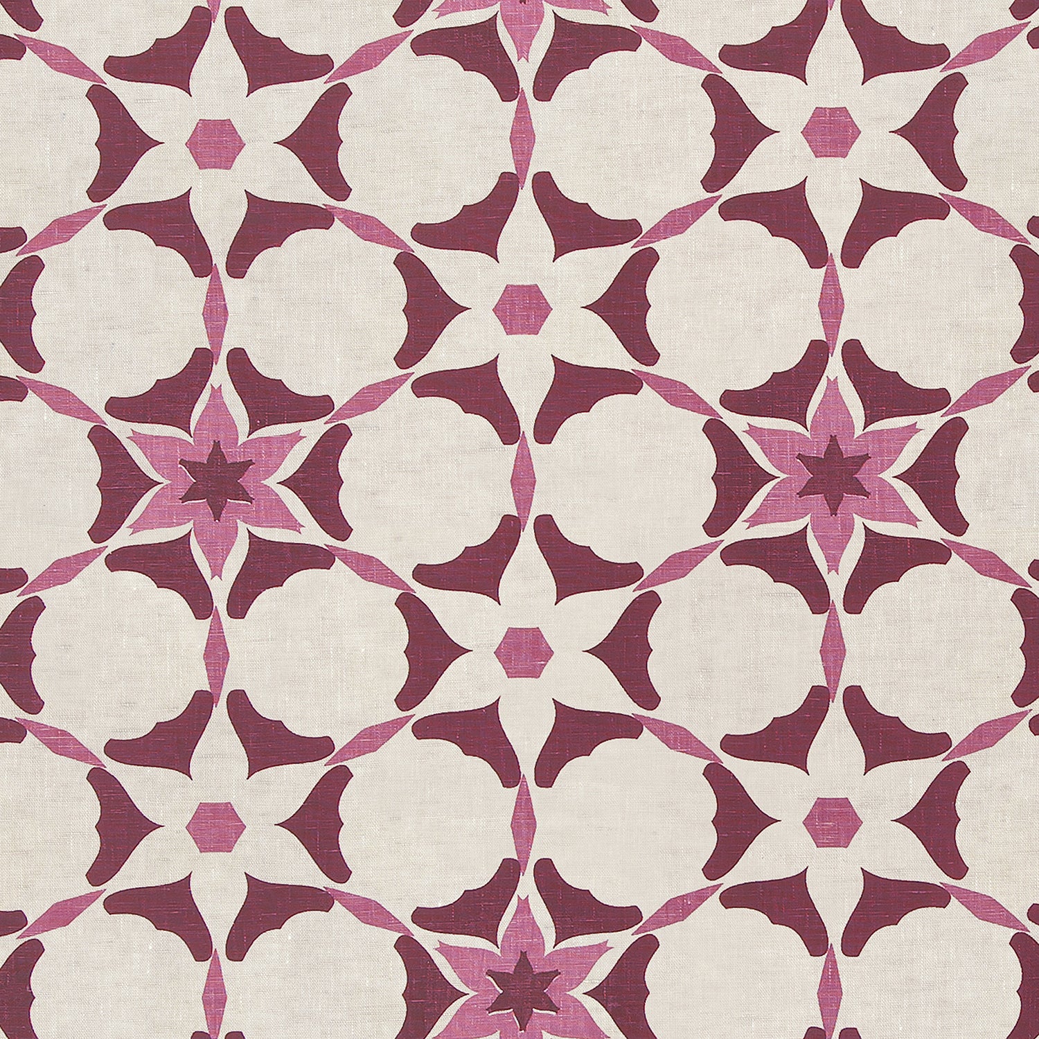 Detail of fabric in a geometric star print in shades of pink and maroon on a cream field.