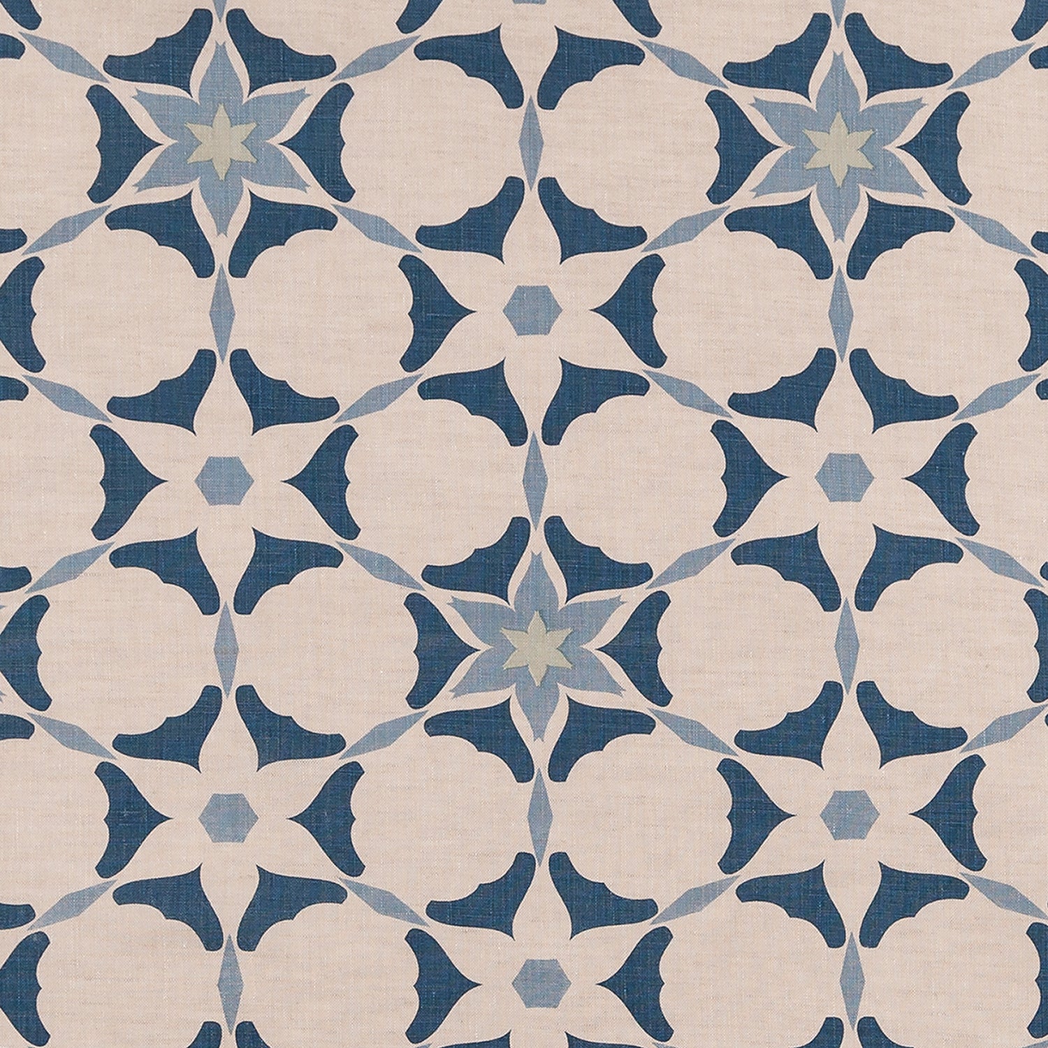 Fabric in a geometric star print in shades of blue and navy on a tan field.
