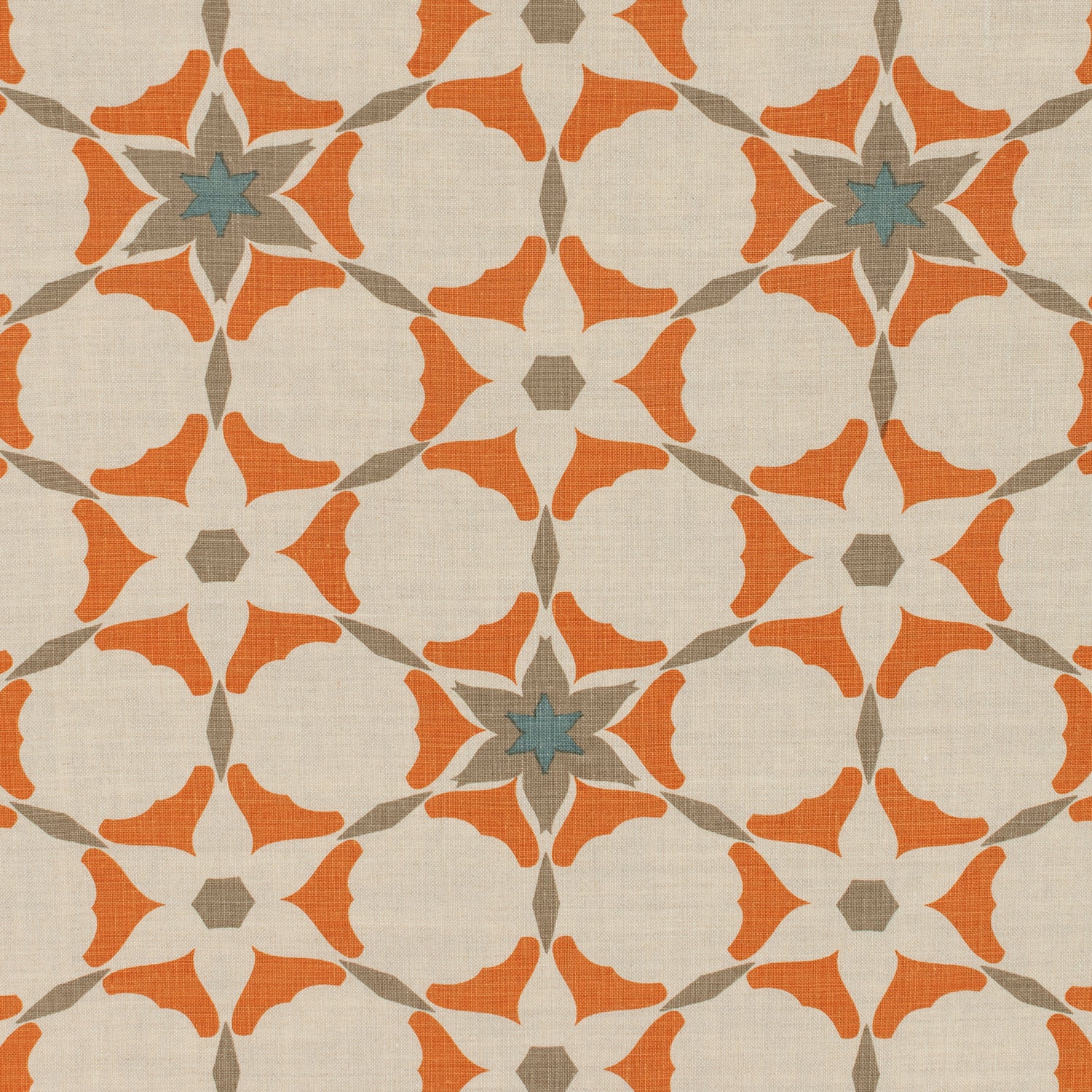 Detail of fabric in a geometric star print in shades of coral and brown on a tan field.