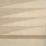 Detail of a handwoven rug in a geometric design in shades of beige. 
