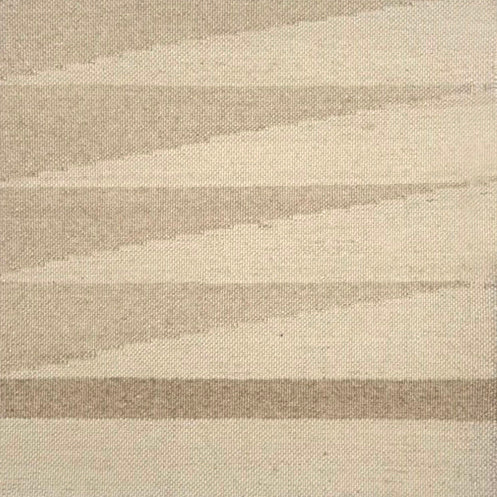 Detail of a handwoven rug in a geometric design in shades of beige. 