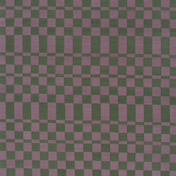 Detail of dhurrie rug in a checkerboard pattern of green and purple