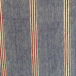 Detail of fabric in an irregular stripe print in navy and rust on a cream field.