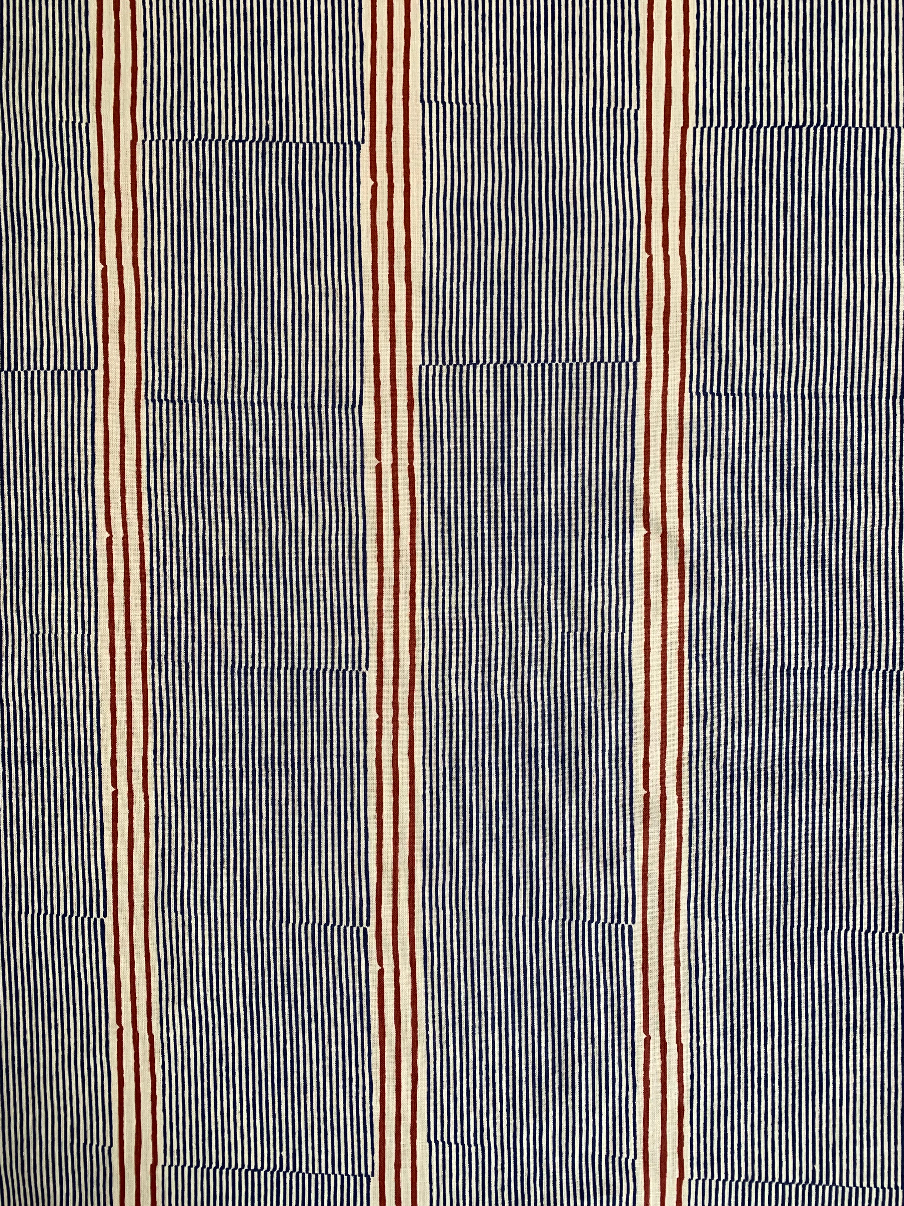 Detail of fabric in an irregular stripe print in navy and rust on a cream field.