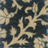 Close-up of a handknotted rug in afloral paisley in cream on a charcoal field