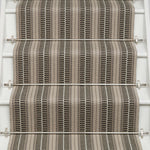 Striped flatweave runner in tan and black and white on white staircase