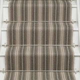 Striped flatweave runner in tan and black and white on white staircase