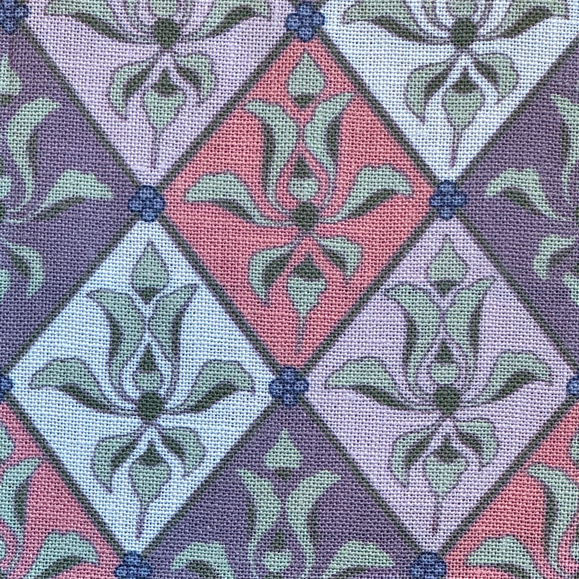 Patterned fabric with a diamond design featuring green leaves on a purple and pink background