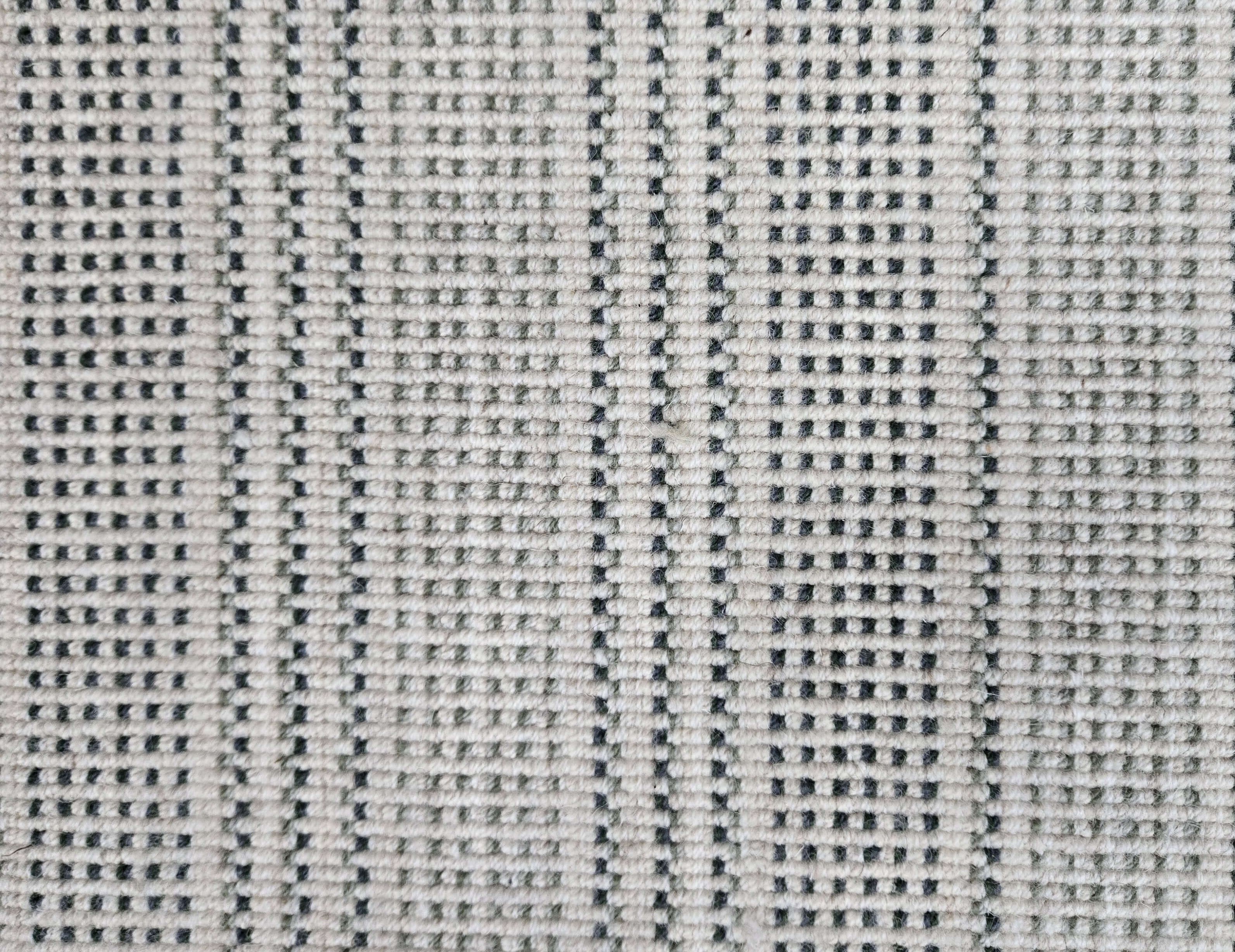 Broadloom carpet in dashed stripe pattern in shades of dark green with cream. 