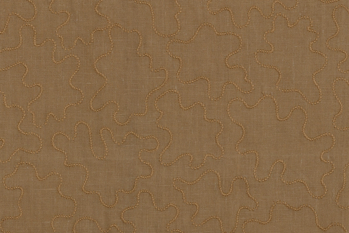 Fabric with an abstract embroidered pattern in brown on a brown field.