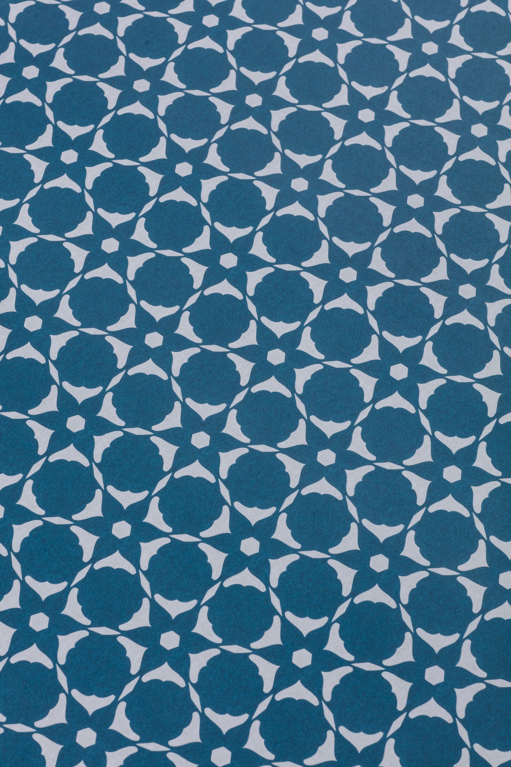Wallpaper detail in a floral lattice print in cream on a indigo blue field.