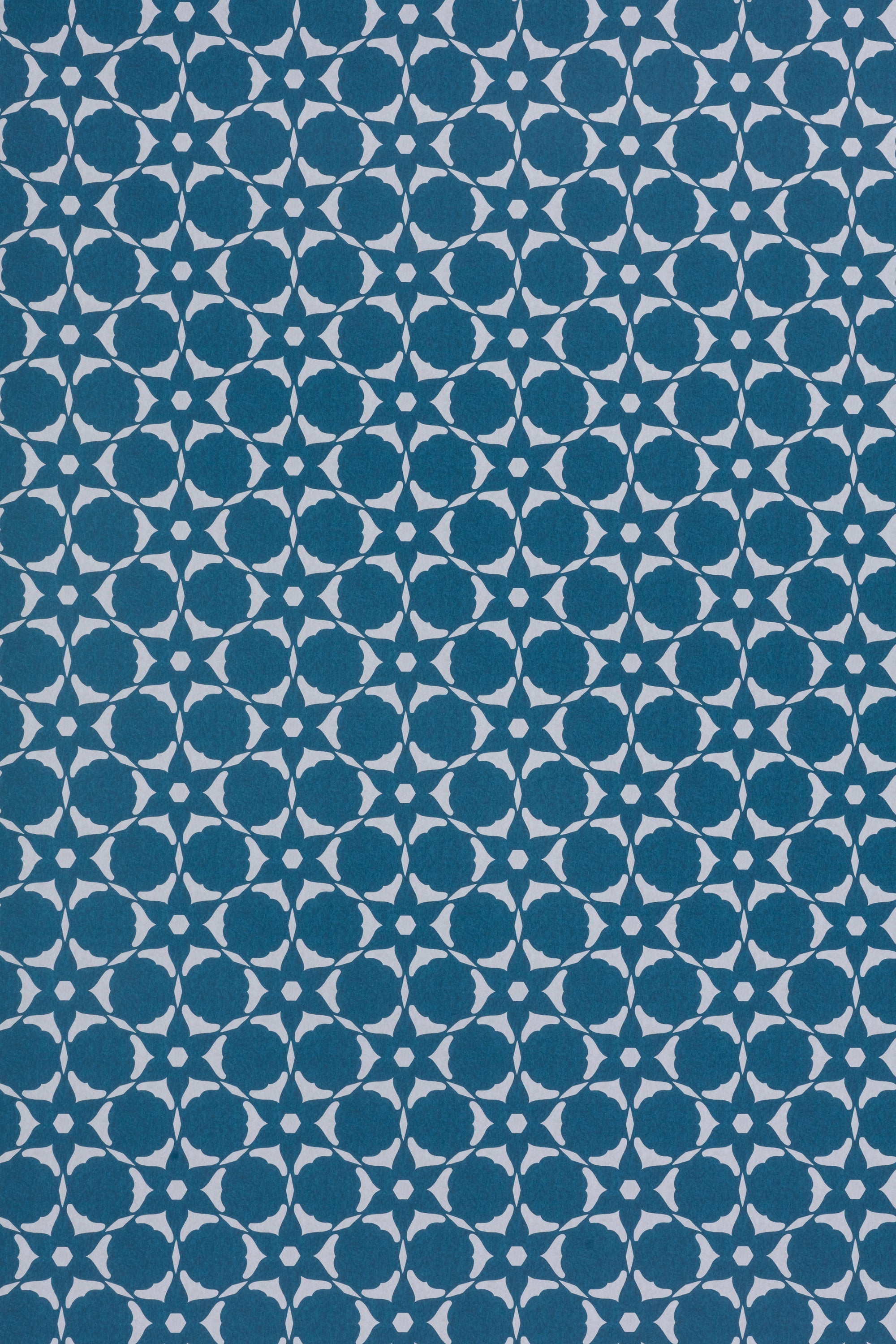 Wallpaper in a floral lattice print in cream on a indigo blue field.