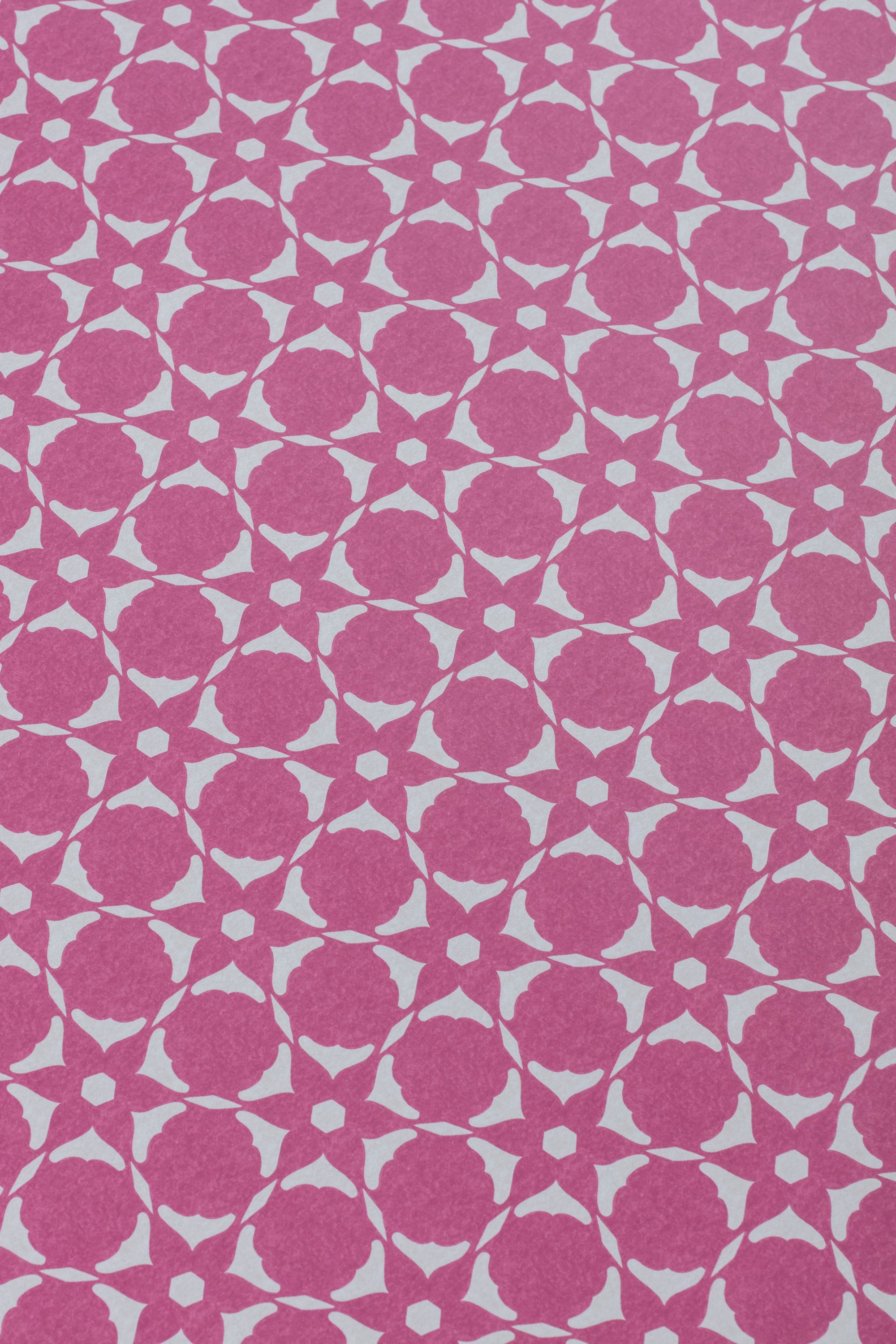 Wallpaper detail in a floral lattice print in cream on a magenta field.