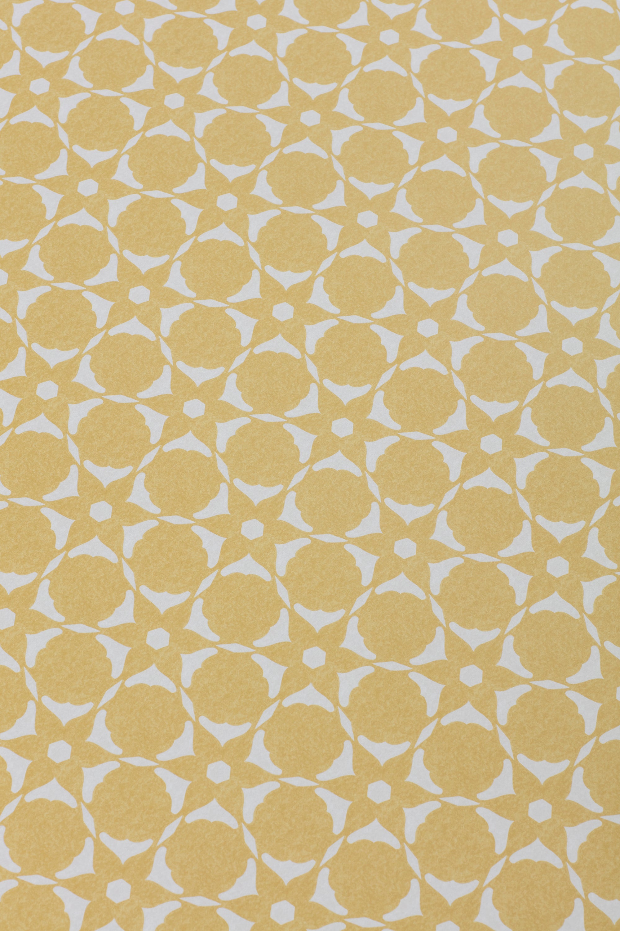 Wallpaper detail in a floral lattice print in  cream on a yellow field