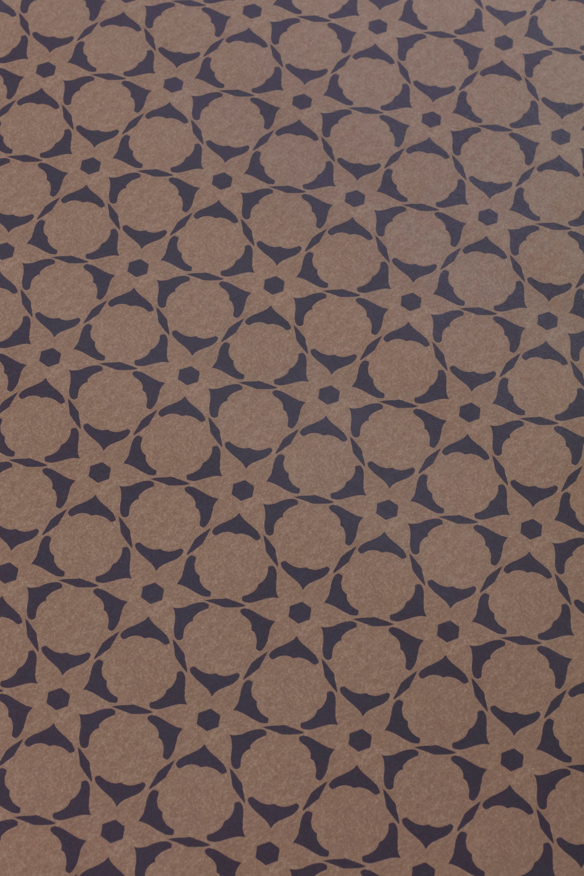 Wallpaper detail in a floral lattice print in navy on a kraft brown field