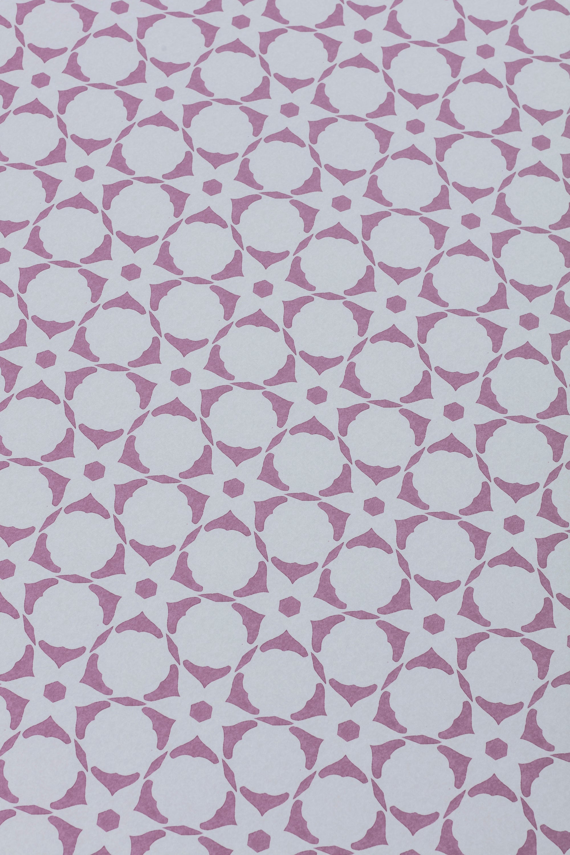Wallpaper detail in a floral lattice print in  purple on a cream field.