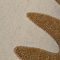 Detail of cream fabric with a wavy dimensional raffia embroidery pattern.