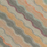 Close-up of fabric with wavy pattern in beige, turquoise, and orange.