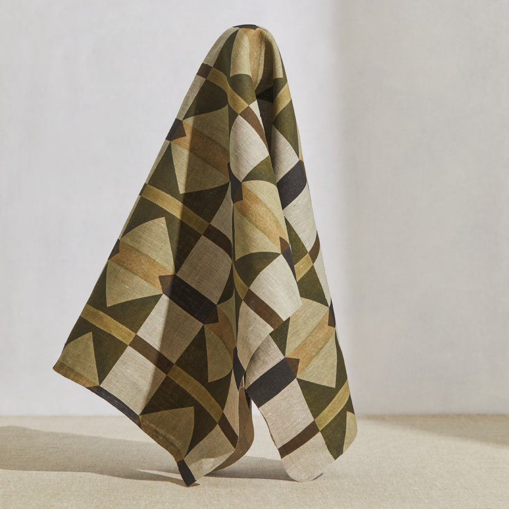 A large piece of draped fabric in a large-scale geometric grid in shades of brown and tan.