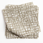 A stack of fabric swatches in a textural wicker pattern in mottled olive on a white field.