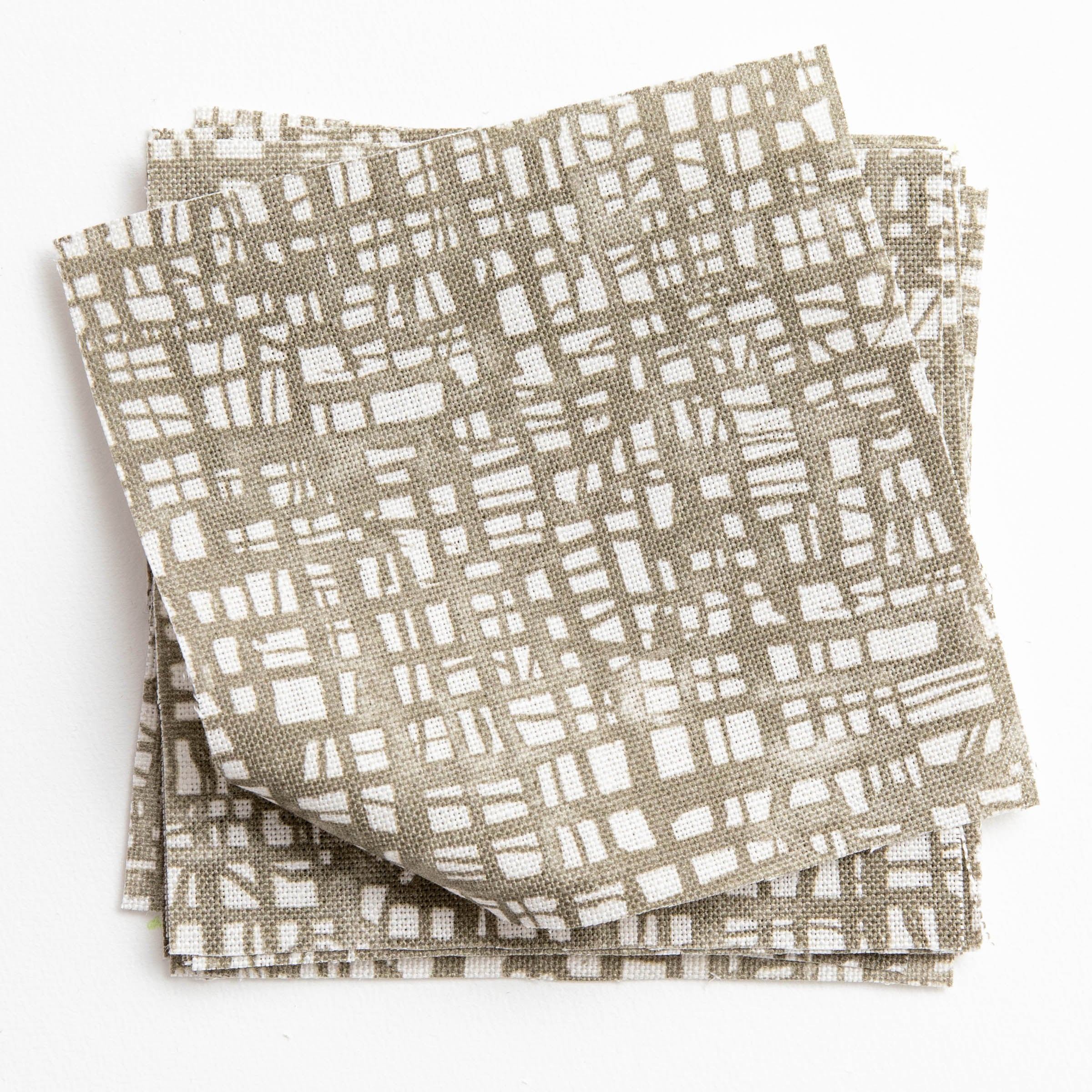 A stack of fabric swatches in a textural wicker pattern in mottled olive on a white field.