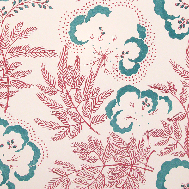 Detail of wallpaper in an intricate floral print in magenta and teal on a cream field.
