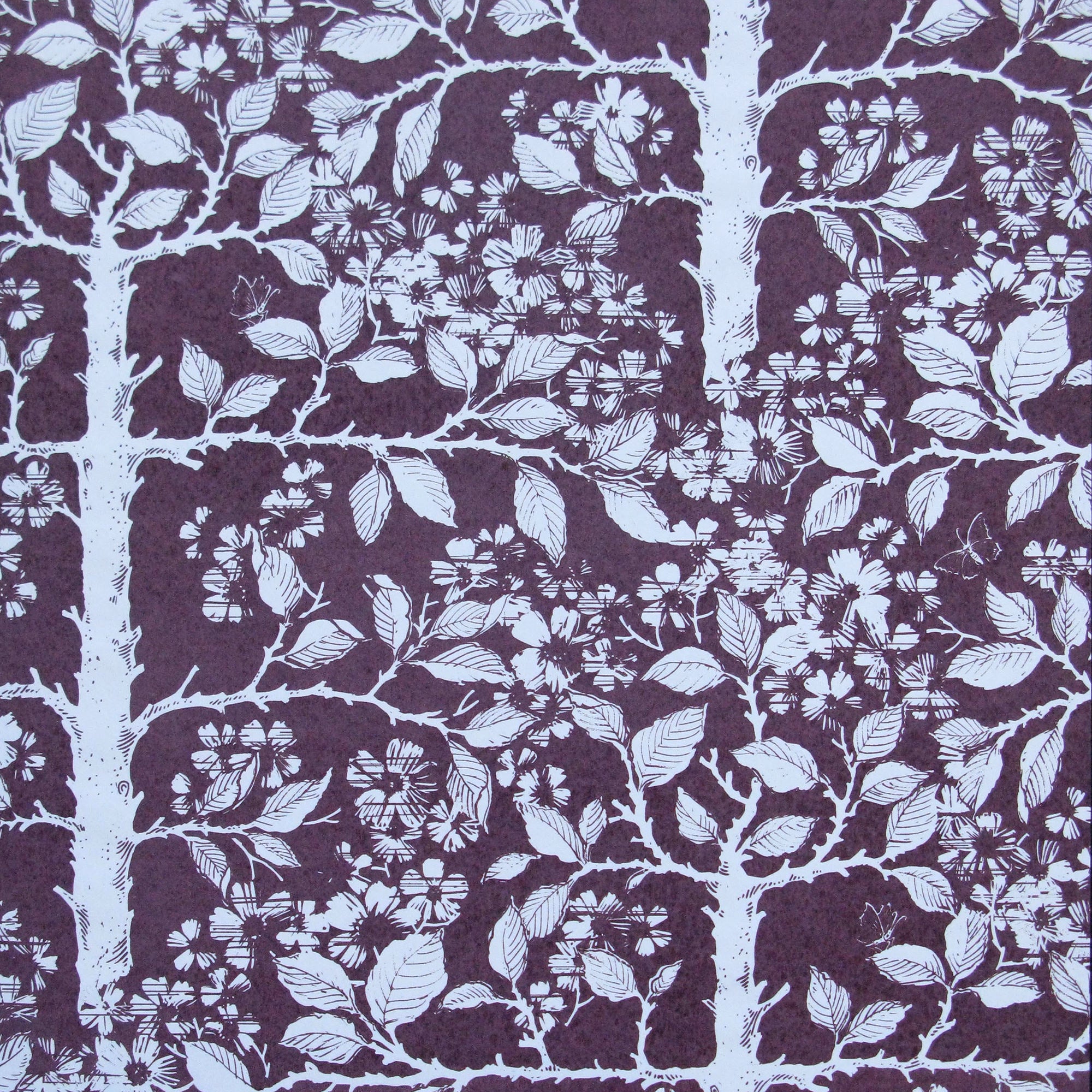 Detail of wallpaper in a large-scale tree and leaf print in white on a dark plum field.