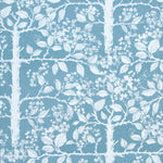 Detail of wallpaper in a large-scale tree and leaf print in white on a light blue field.