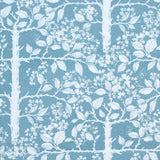 Detail of wallpaper in a large-scale tree and leaf print in white on a light blue field.