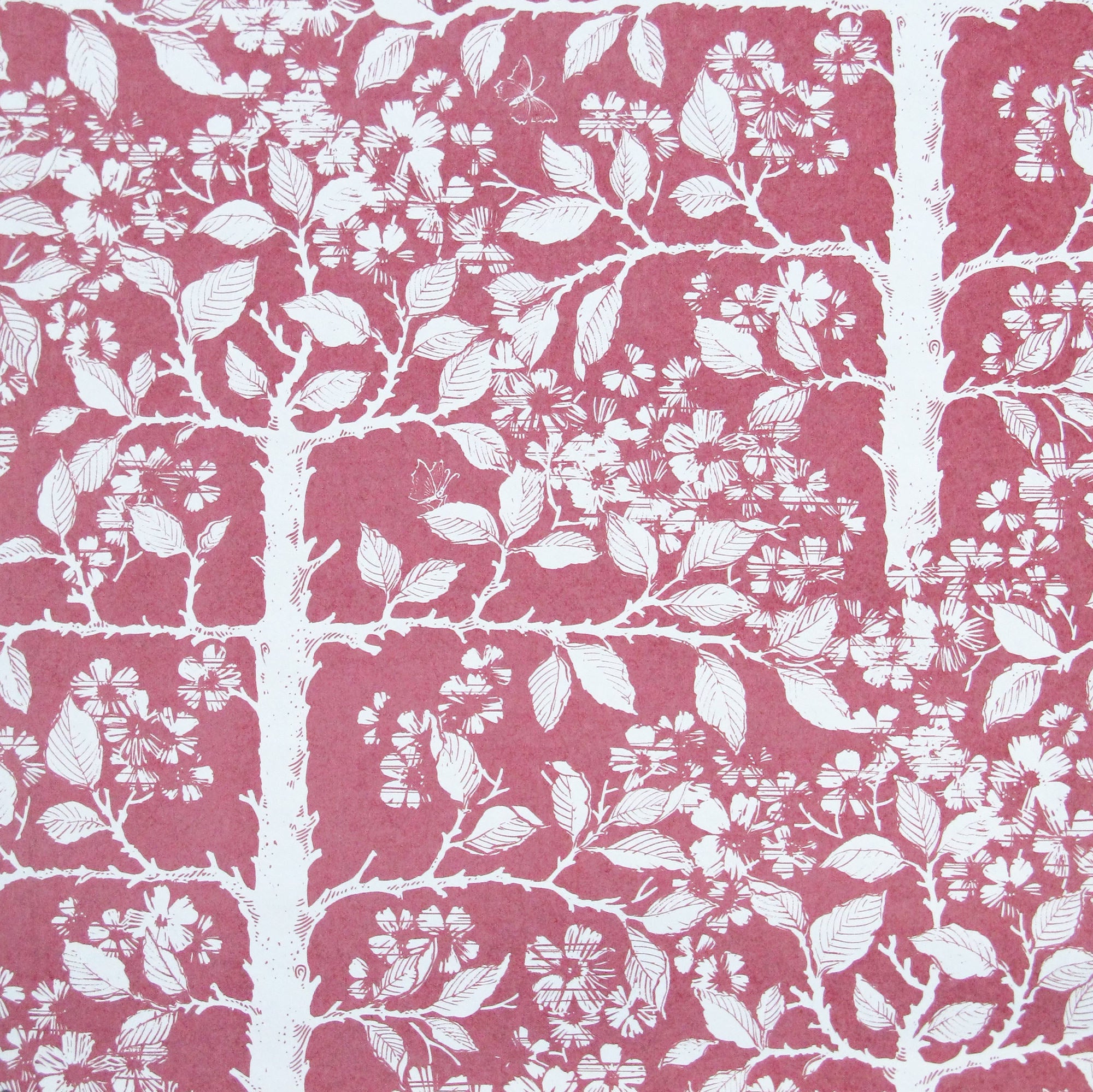 Detail of wallpaper in a large-scale tree and leaf print in white on a rose field.