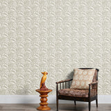 Armchair and end table in front of a wall papered in a repeating botanical print in cream and white.