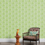 Armchair and end table in front of a wall papered in a repeating botanical print in green and white.