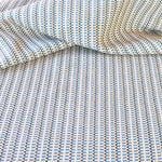 Detail of a draped hand-woven cotton striped fabric in blue, cream and navy.