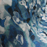 Close-up of velvet fabric in an abstract paint print in shades of blue, navy and turquoise.