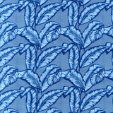 Detail of fabric in a dense leaf print in navy and blue on a blue field.