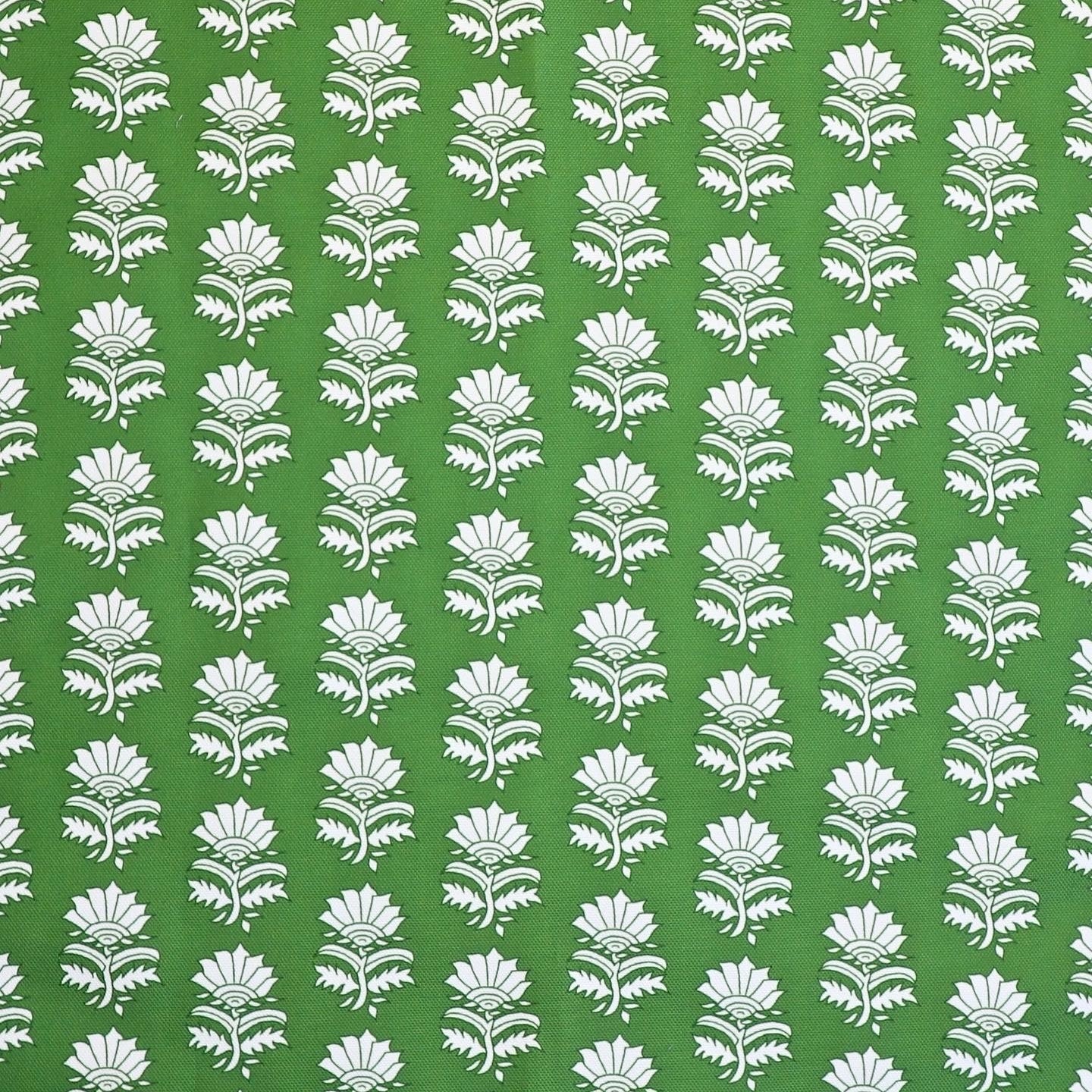 Detail of fabric in a repeating thistle print in white and green on a green field.